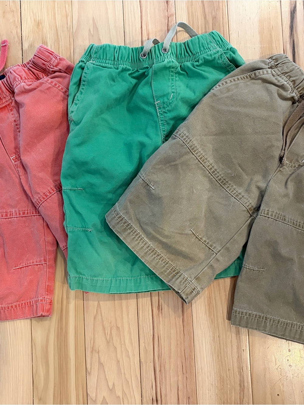 Three pairs of Miniboden Pull-On Shorts 3-4 - Green, faded coral and beige